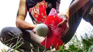 Ren crouches in grass holding a lacrosse ball and a "magic band".